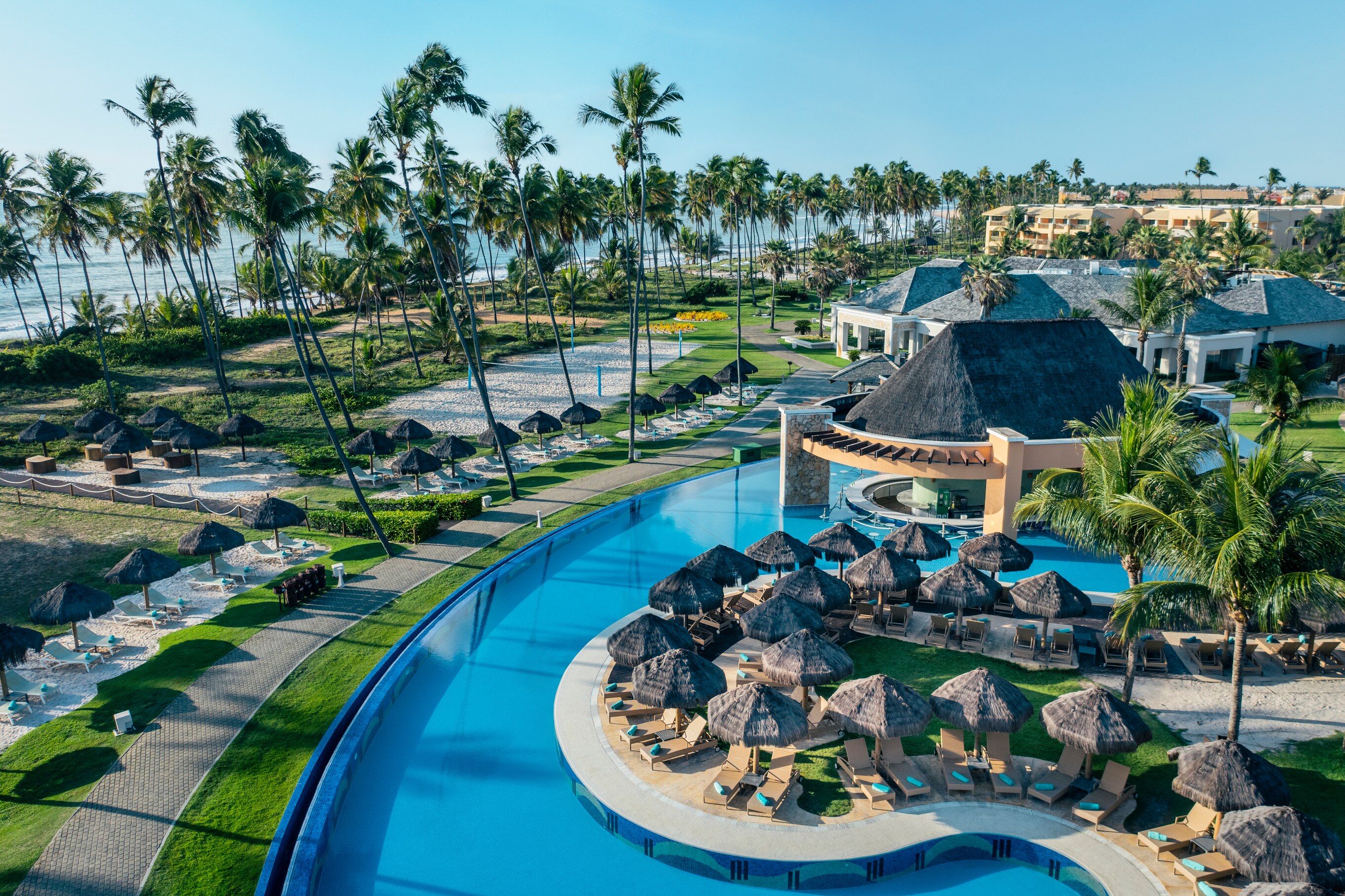Tropical resort pool with palm trees and cabanas